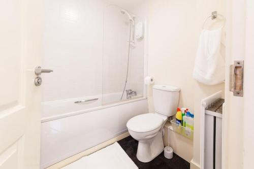 a white bathroom with a toilet and a shower at Fusilier apartment wrexham city in Wrexham