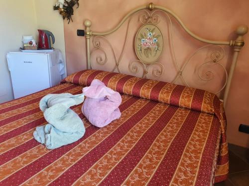 two stuffed animals are laying on a bed at Agriturismo Cascina L'Arché in Santo Stefano Belbo