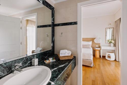 a bathroom with a sink and a mirror at Bello Blu Luxury Villa in Asgourou