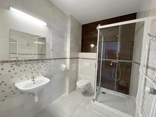 a bathroom with a toilet and a sink and a shower at Kompleks Hotelowo-Rekreacyjny “Kasztelanka” in Ciechocinek
