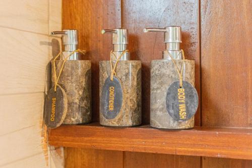 a group of four bottles sitting on a shelf at NILUH Private Villas Ubud in Ubud