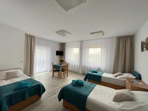 a hotel room with two beds and a table at Kompleks Hotelowo-Rekreacyjny “Kasztelanka” in Ciechocinek