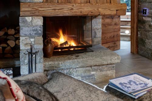 a fireplace in a living room with a couch at Camere nel centro di Cervina con colazione, accesso SPA e WiFi - Matterhorn Retreat Francois in Breuil-Cervinia