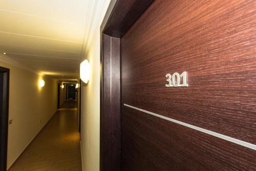 una porta in legno con un numero sopra in un corridoio di Kiara Residence a Giulianova