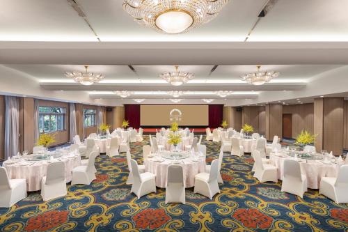 a conference room with white tables and chairs and a chandelier at City Hotel Xiamen-Free Welcome Fruits in Xiamen