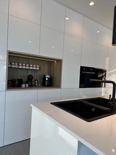 a kitchen with a black sink and white cabinets at VILLA MARIAH Barrosa Playa in Novo Sancti Petri