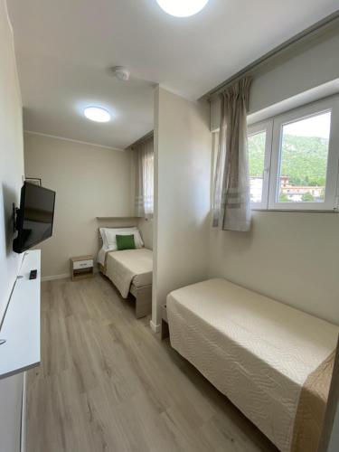 a hotel room with two beds and a flat screen tv at Albergo Lodrino in Villa