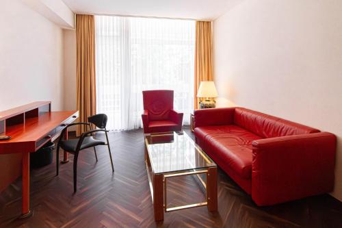 a living room with a red couch and a desk at Müggelseeperle in Berlin