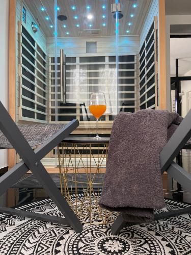un verre de jus d'orange assis sur une table dans une pièce dans l'établissement Sinalospa - Culiacàn - Appartement Jardin Jacuzzi Sauna à 5 minutes de Nancy Place Stanislas, à Champigneulles