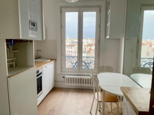une cuisine avec une table et des chaises et une fenêtre dans l'établissement Studio Vichy avec vue, à Vichy