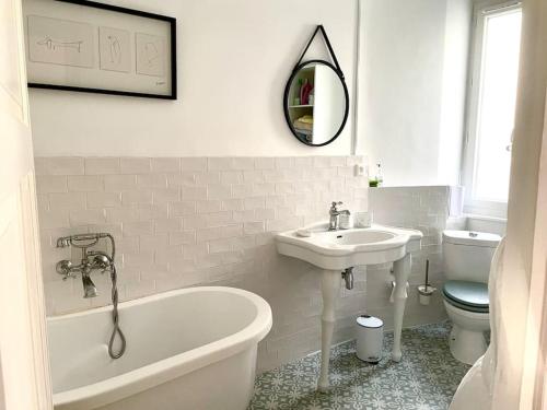 une salle de bain avec un lavabo, une baignoire et des toilettes dans l'établissement Studio Vichy avec vue, à Vichy