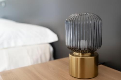 a silver and gold lamp on a table next to a bed at Villa Angeline in Guarazzano