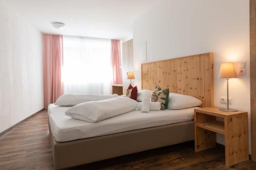 a bedroom with a large white bed with a window at Pitztal Living Apartments in Jerzens