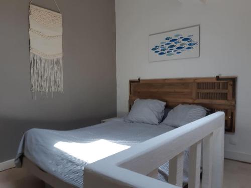 a bedroom with a bed with a wooden headboard at Particulier in Palavas-les-Flots