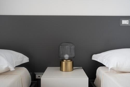 a lamp on a night stand next to two beds at Villa Angeline in Guarazzano