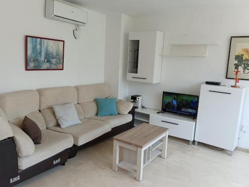 salon z kanapą i telewizorem w obiekcie Holiday Apartment Torres Montecarlo w mieście Benidorm