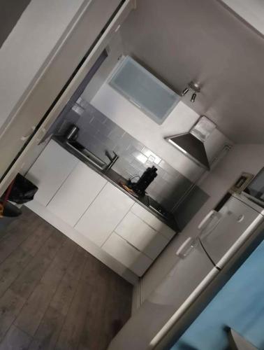 - une vue de tête sur une cuisine équipée d'appareils blancs dans l'établissement Particulier, à Palavas-les-Flots