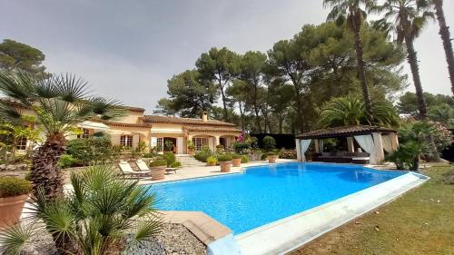 une piscine devant une maison dans l'établissement Villa Parc Saint-Martin, à Mougins