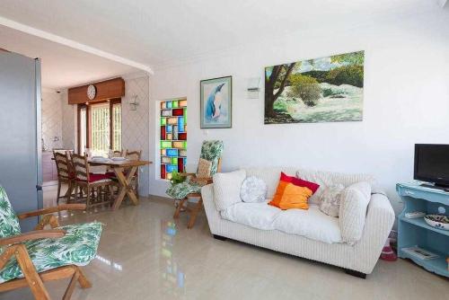a living room with a white couch and a table at Caleta del Sol con piscina terraza y playa in Caleta De Velez