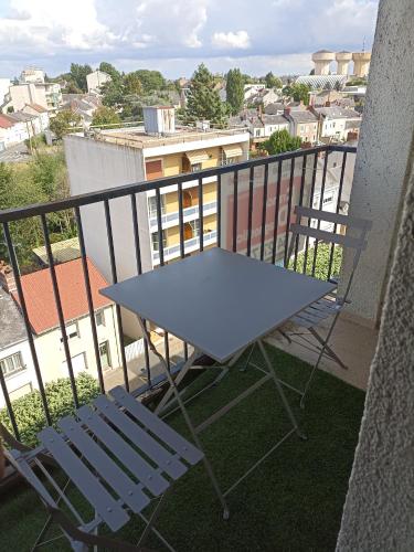 einen Tisch und zwei Stühle auf dem Balkon in der Unterkunft Un temps pour soi in Châteauroux