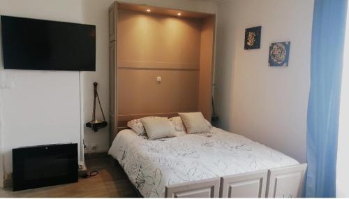 ein kleines Schlafzimmer mit einem Bett und einem Flachbild-TV in der Unterkunft Un temps pour soi in Châteauroux