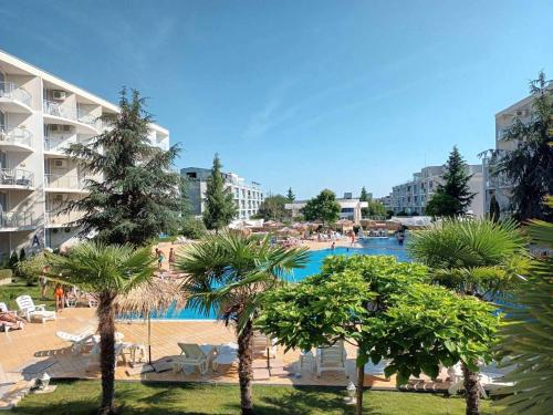 a resort with a pool and palm trees and buildings at Design Studio in Atlantis Resort&SPA, Burgas Airport in Burgas City