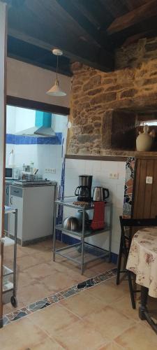 a kitchen with a table and a stove in it at WITERICUS hospedaxe in Guitiriz
