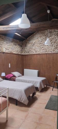 a bedroom with two beds and two pendant lights at WITERICUS hospedaxe in Guitiriz