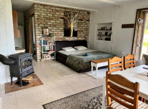 a bedroom with a bed and a wood stove at Adutiškio pirtis in Švenčionys