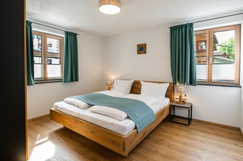 Schlafzimmer mit einem Bett und grünen Vorhängen in der Unterkunft Ferienwohnungen Zober am Mühlbach in Oberammergau