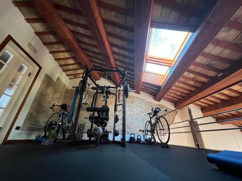 a gym with two bikes in a room with a window at ai18diamanti in Saludecio
