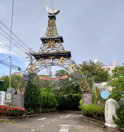 una entrada a un arco con una torre de reloj en Ai Yi Bao Motel, en Toufen
