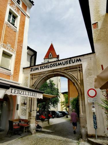 a man walking through an archway in a city at Zentrumsnahe Privatunterkunft Freistadt in Freistadt