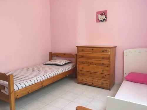 a small bedroom with a bed and a dresser at Karipidis houses in Nea Iraklia