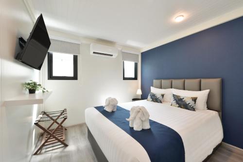 a bedroom with a large bed with a blue wall at Gate43 Airport Hotel in Lat Krabang