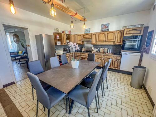 eine Küche mit einem Esstisch und Stühlen in der Unterkunft Villa Belz, 3 pièces, 2 personnes - FR-1-479-142 in Belz