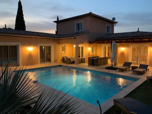 une villa avec piscine devant une maison dans l'établissement Villa Giovanna à Saint-Raphaël avec piscine chauffée, à Saint-Raphaël