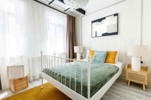 a white bedroom with a bed with orange and blue pillows at Chic Flat 5 min to Galata Tower in Istiklal Ave in Istanbul