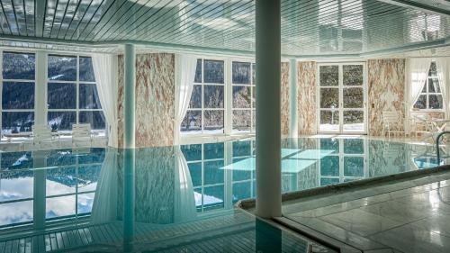 a swimming pool in a house with windows at Villa Bostele with Seven Bedrooms, Indoor Pool and Two Saunas in Bad Kleinkirchheim