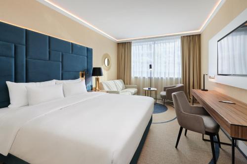 シュチェチンにあるラディソンブルー シュチェチンの大きなベッドとデスクが備わるホテルルームです。