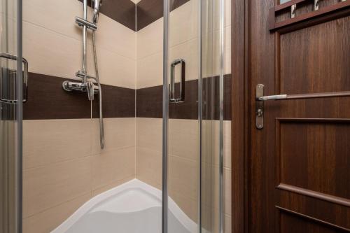 a bathroom with a shower and a bath tub at Market Square Corner Apartment Kuźnicza by Renters in Wrocław