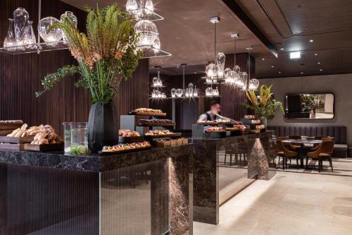 ミラノにあるHotel Cristoforo Colombo - Preferred Hotels & Resortsの食べ物が置かれたカウンターのあるレストラン
