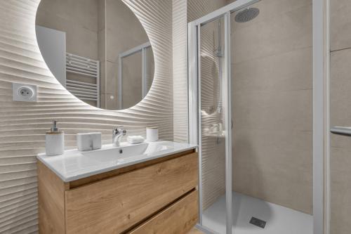 une salle de bain avec un lavabo et un miroir dans l'établissement L'Azzurri - Charmant appartement pour 4, à Toulouse