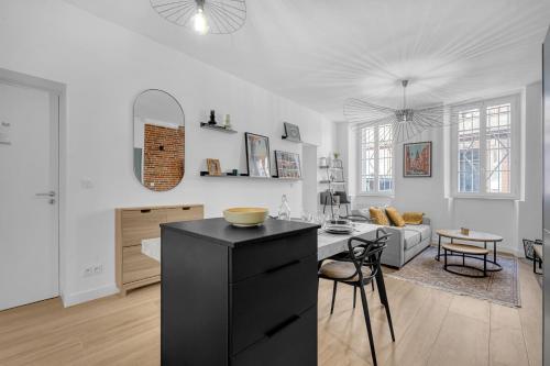 - une cuisine et un salon avec un îlot noir dans la chambre dans l'établissement L'Azzurri - Charmant appartement pour 4, à Toulouse