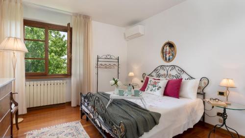 um quarto com uma cama branca e almofadas cor-de-rosa em VILLA IRENE 6, Emma Villas em Montecarlo