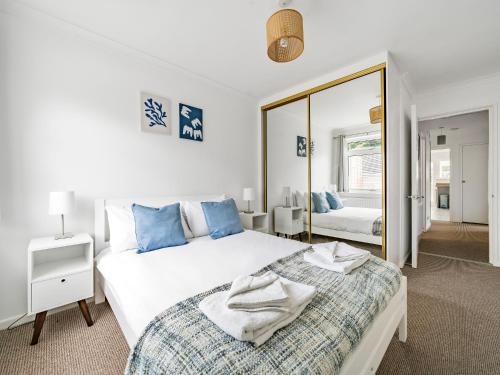 een witte slaapkamer met een bed en een spiegel bij Pass the Keys Modern Spacious 3BR Bungalow Parking Oxford in Oxford
