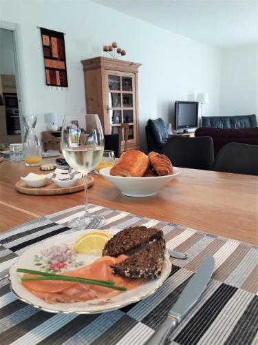une table avec une assiette de nourriture et un verre de vin dans l'établissement Ici et Là - Chambres d'hôtes, à Velleron