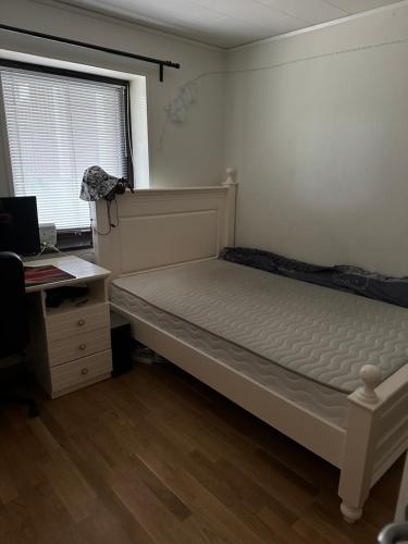 um quarto com uma cama, uma secretária e uma janela em Suspend service em Täby