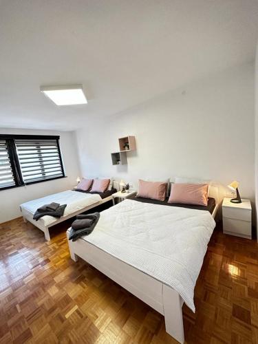 a bedroom with two beds and a couch at Family Apartman in Donji Milanovac