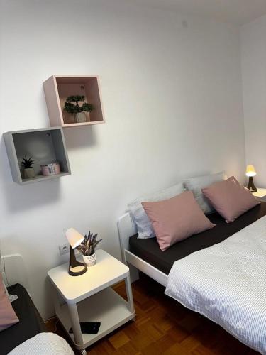 a room with two beds and a tv on the wall at Family Apartman in Donji Milanovac